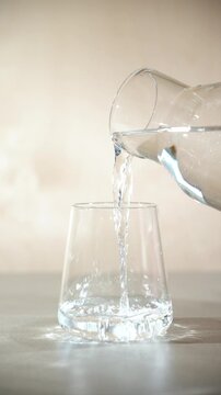 pouring clear crystal drinking water from a jug into a glass