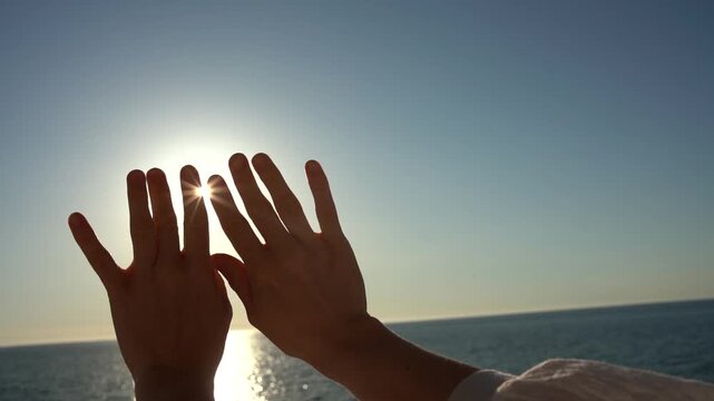 Sunset hands ocean Silhouette of hands reaching toward the sun over the sea conveying a sense of freedom and hope