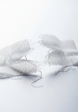 A ripped gauze medical dressing sitting on a clean surface showing the concept of failure, temporary fix, or wound vulnerability, failure, accident, adhesive