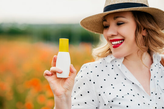 Smiling woman holding blank repellent bottle mockup. Body skin care and personal hygiene protection from tick borne encephalitis and lyme disease.