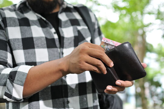 man holding indonesian rupiah