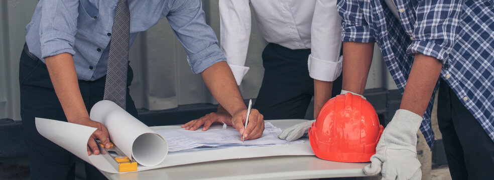 Banner Contractor construction engineer meeting on architect table at construction site. Businessman engineer manager discuss talk together foreman team builder using measure tape with copy space.