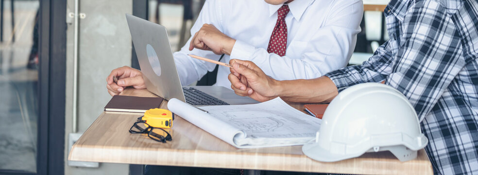 Banner Contractor construction engineer meeting on architect table at construction site. Businessman engineer manager discuss talk together foreman team builder using measure tape with copy space.