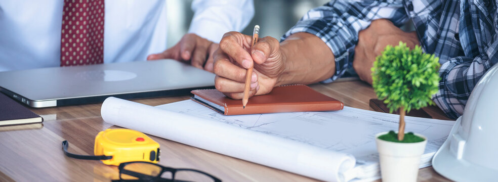 Banner Contractor construction engineer meeting on architect table at construction site. Businessman engineer manager discuss talk together foreman team builder using measure tape with copy space.