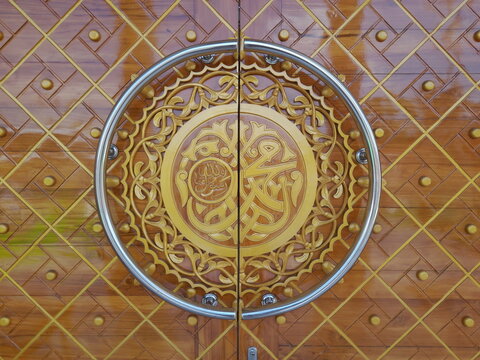 Close-up view of golden door for a Mosque with Arabic calligraphy Muhammad Rasulullah. Arabic calligraphy depicting the name of the Prophet Muhammad written on the door of a mosque