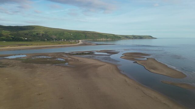 Drone flying forward over Fairbourne sandbanks near Barmouth estuary Wales