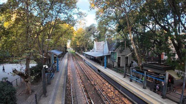 Diagonal view of historic Coghlan station with platforms tracks and shelters under evening sun in autumn Buenos Aires Argentina travel scene