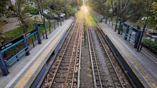 Warm sunset over train tracks towards Bartolome Mitre station from iron bridge in Coghlan Buenos Aires Argentina autumn infrastructure scene