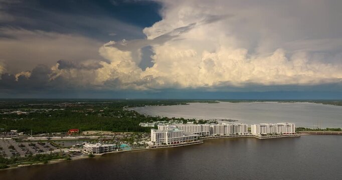 Stormy dark skies over tourist resort complex on bay shore. Hurricane conditions threaten coastal property.