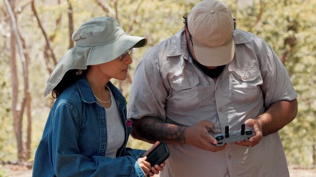 Park rangers operating drone remote controller outdoors