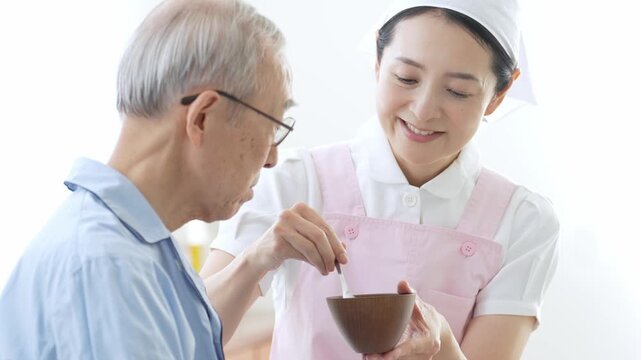 高齢者の食事の介助をする介護士