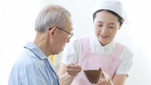 高齢者の食事の介助をする介護士