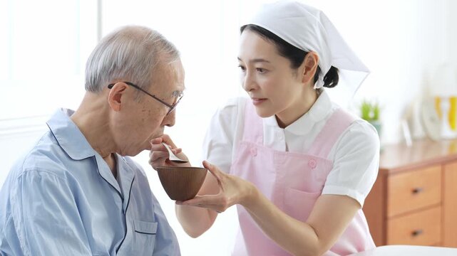 高齢者の食事の介助をする介護士