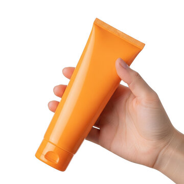 Hand holding an orange cosmetic tube for cream or lotion isolated on transparent background