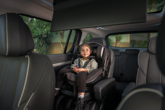 preschool child girl watching rear entertainment screen or ceiling screen while sitting in car seat, safety baby chair travelling