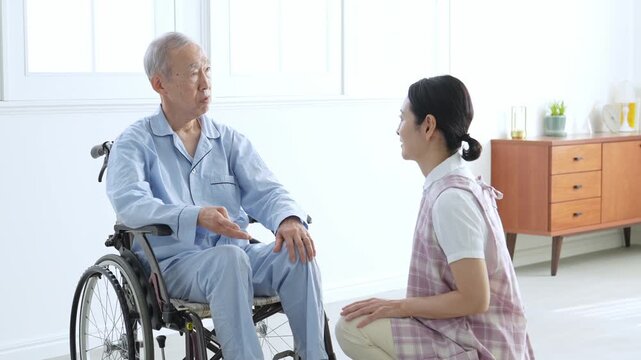 車椅子に乗った高齢者のサポートをする介護士