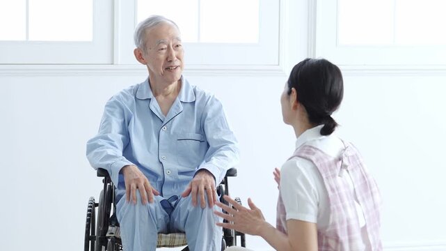 車椅子に乗った高齢者のサポートをする介護士