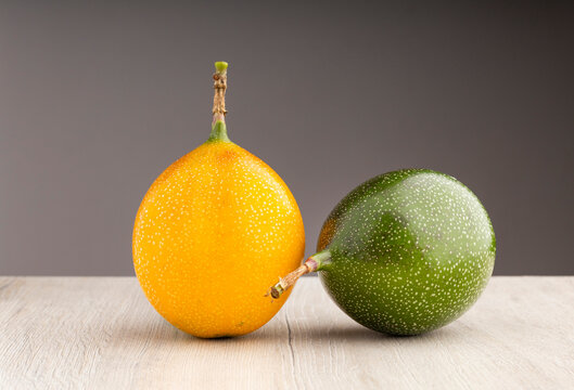 Unripe and ripe granadilla against a neutral background, ideal for healthy eating, agriculture, and tropical fruit concepts - Passiflora ligularis
