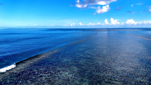 Aerial view of the turquoise coral reef and deep blue ocean waters off the coast of Trou-aux-Biches, Pamplemousses District, Mauritius.