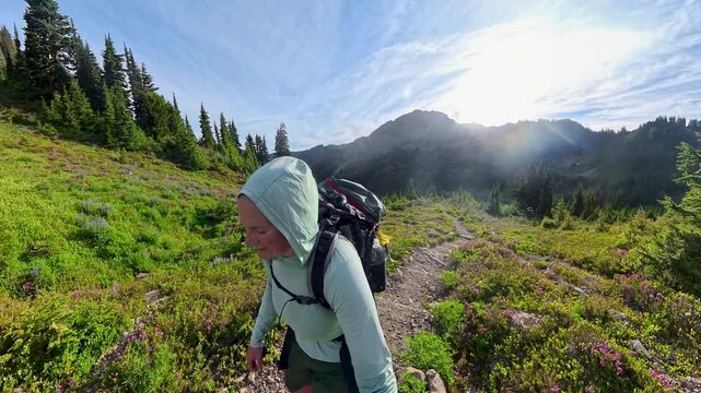 Hooded Woman Hikes on Trail through Mountain Heather in Washington Park