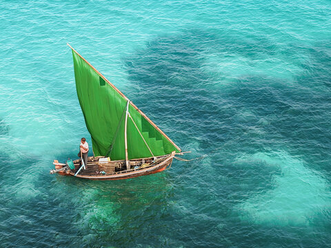 Aerial view of a traditional wooden boat with a vibrant green sail and a fisherman on board, sailing across the clear turquoise waters of Vaikaradhoo, Haa Dhaalu City, Maldives.