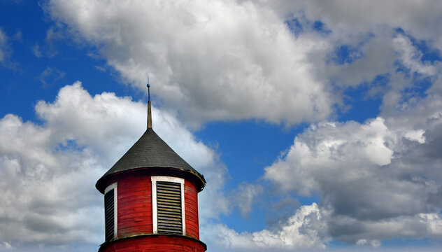 Red Wooden Barn Has Round Cupola With Vents