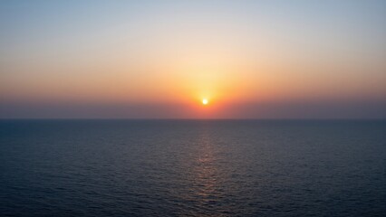 Obraz premium Sunset Over the Ocean: A breathtaking sunset paints the sky with hues of orange, pink, and purple above a calm, vast ocean, creating a serene and tranquil seascape.