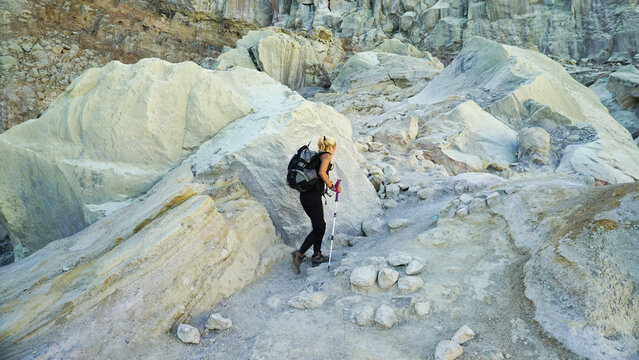 Woman Hiking Through Rocky Terrain at Ijen Crater, Banyuwangi Indonesia.