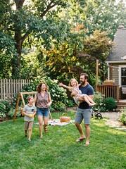 Obraz premium Joyful family enjoying a sunny summer afternoon picnic and playing in their backyard garden