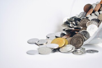 A scattered heap of mixed Malaysian ringgit coins in silver and gold colors on a seamless white surface, perfect for financial and economic concepts. © Akram