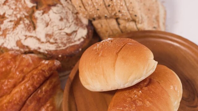 Assorted Fresh Bakery Bread and Pastries on Wooden Plate