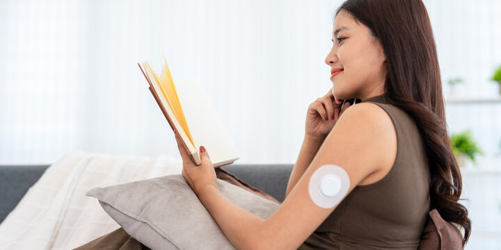 a woman with A Continuous Glucose Monitor (CGM) wearable device  tracks  interstitial fluid glucose levels 24 hours a day.
