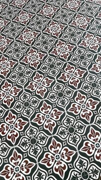 Classic retro floor tile texture background with black white and maroon traditional ornaments.
