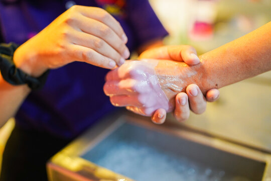 Therapist applying paraffin wax treatment on hand