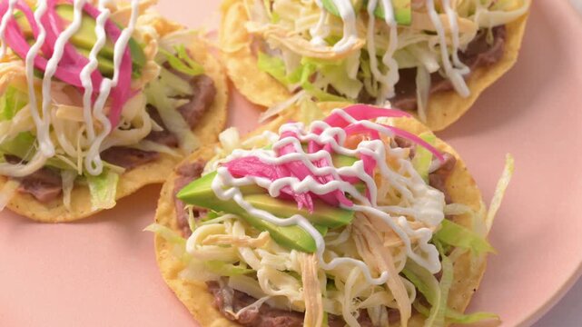 Close-up of traditional Mexican chicken tostadass with refried beans, avocado and sour cream