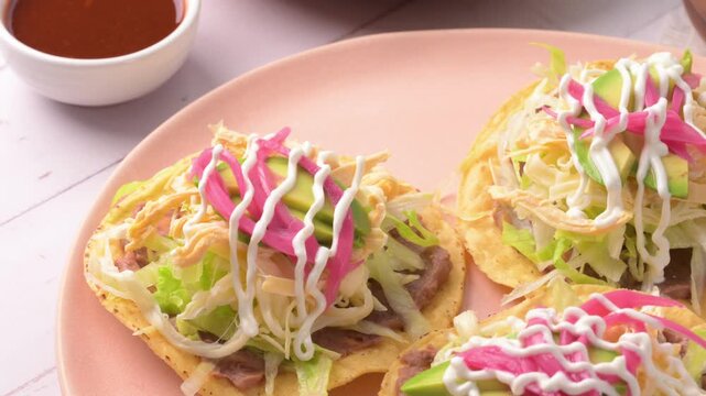 Delicious Mexican tostadas with chicken, lettuce, avocado and pickled onions