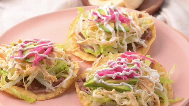 Mexican food, chicken tostadas served on a slowly rotating pink plate