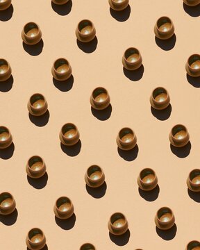 Mustard ceremonial drink vessels in a Quechua tradition pattern over a warm sand background for textile and wallpaper design