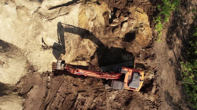 Aerial view from above of an excavator operating at dawn.