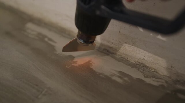 Close-up of a heat gun drying fresh filler too quickly &ndash; a common DIY mistake. Forced heat makes the surface skin over and crack instead of curing evenly. How not to repair a wall.