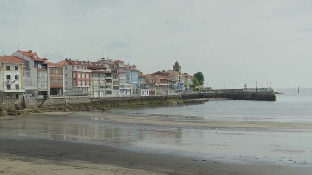 Luanco Coastal Town Waterfront Buildings and Sandy Beach on Cloudy Day in Asturias Spain