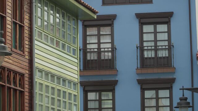 Handheld Close Up of Traditional White Wooden Windows and Balcony on Colorful Building Facade