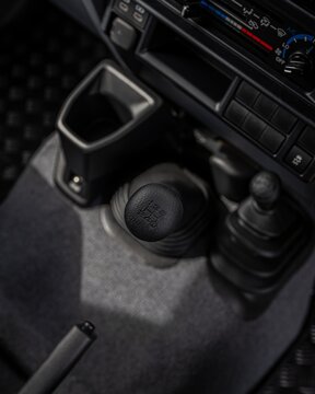 Car interior console with gearshift and cupholder close up.