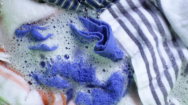 Washing colorful clothes in soapy water at home