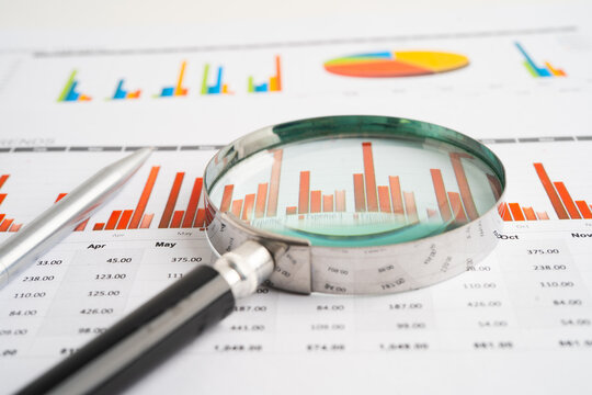 Magnifying glass on spreadsheet and graph paper. Financial data economy, Business.