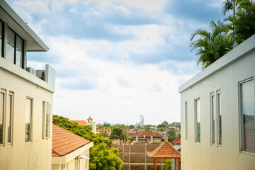 Fototapeta premium View from between buildings showing rooftops and clouds