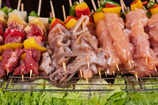 Various meat and seafood skewers preparing for grilling