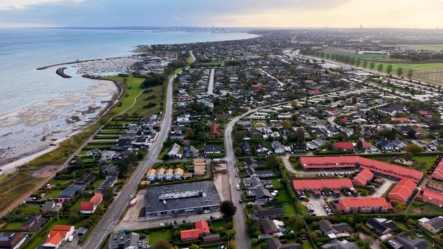 Aerial drone view of Egaa coastal community stretching along the shoreline of Aarhus Bay in Denmark