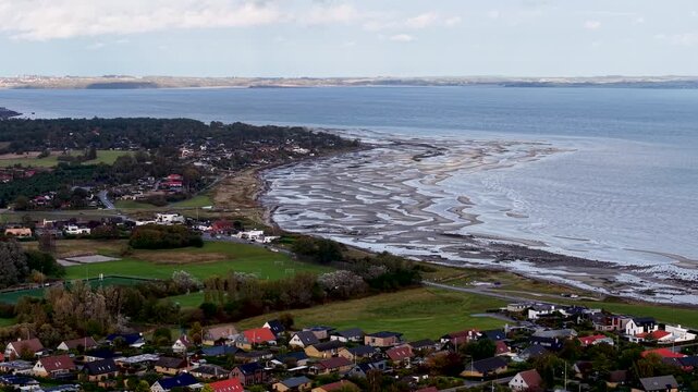 Aerial drone view of the Egaa coastline with Mols Bjerge rising on the distant horizon across Aarhus Bay in Denmark