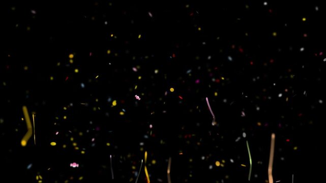 Confetti strips drift slowly through the air in a dark environment creating an elegant and minimal effect that is ideal for digital design projects that require a sophisticated and festive look.